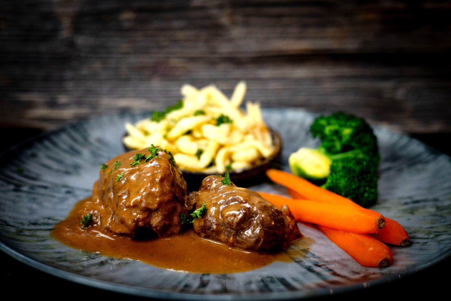 Rinderbäckle auf Teller angerichtet mit Spätzle, Brokkoli und Möhrengemüse