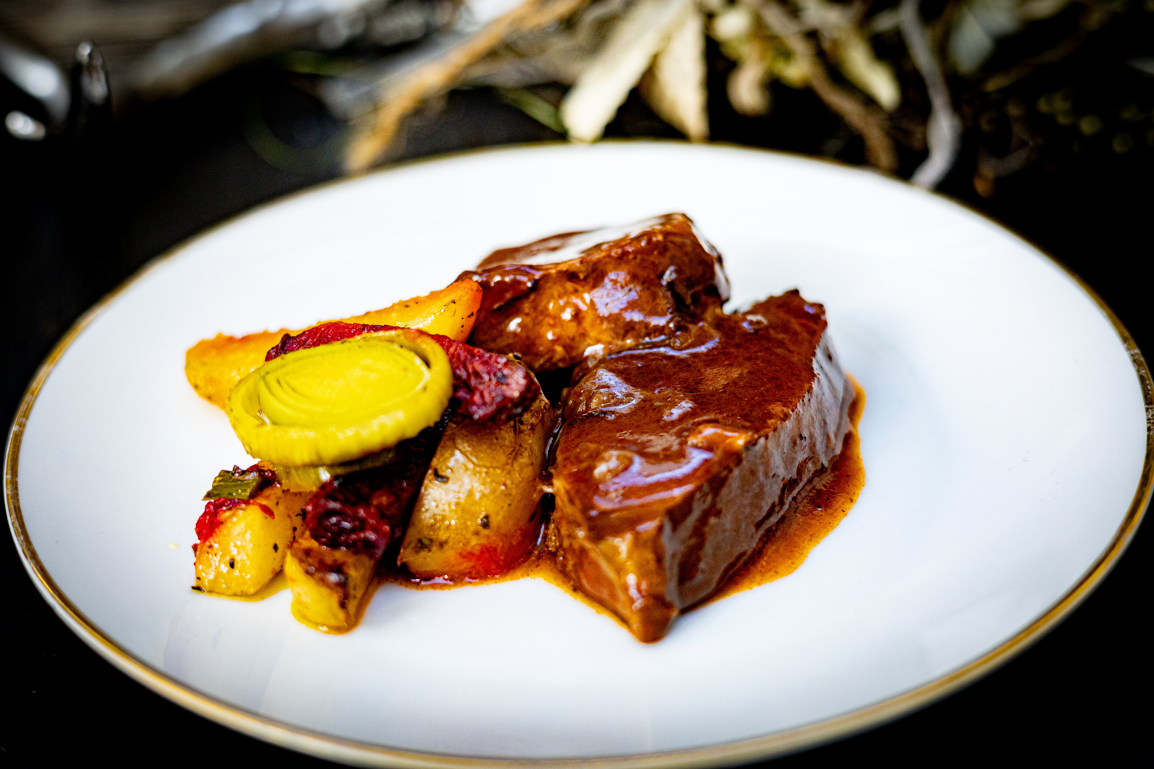 Wildschweinbraten angerichtet auf einem Teller mit Ofenkartoffeln